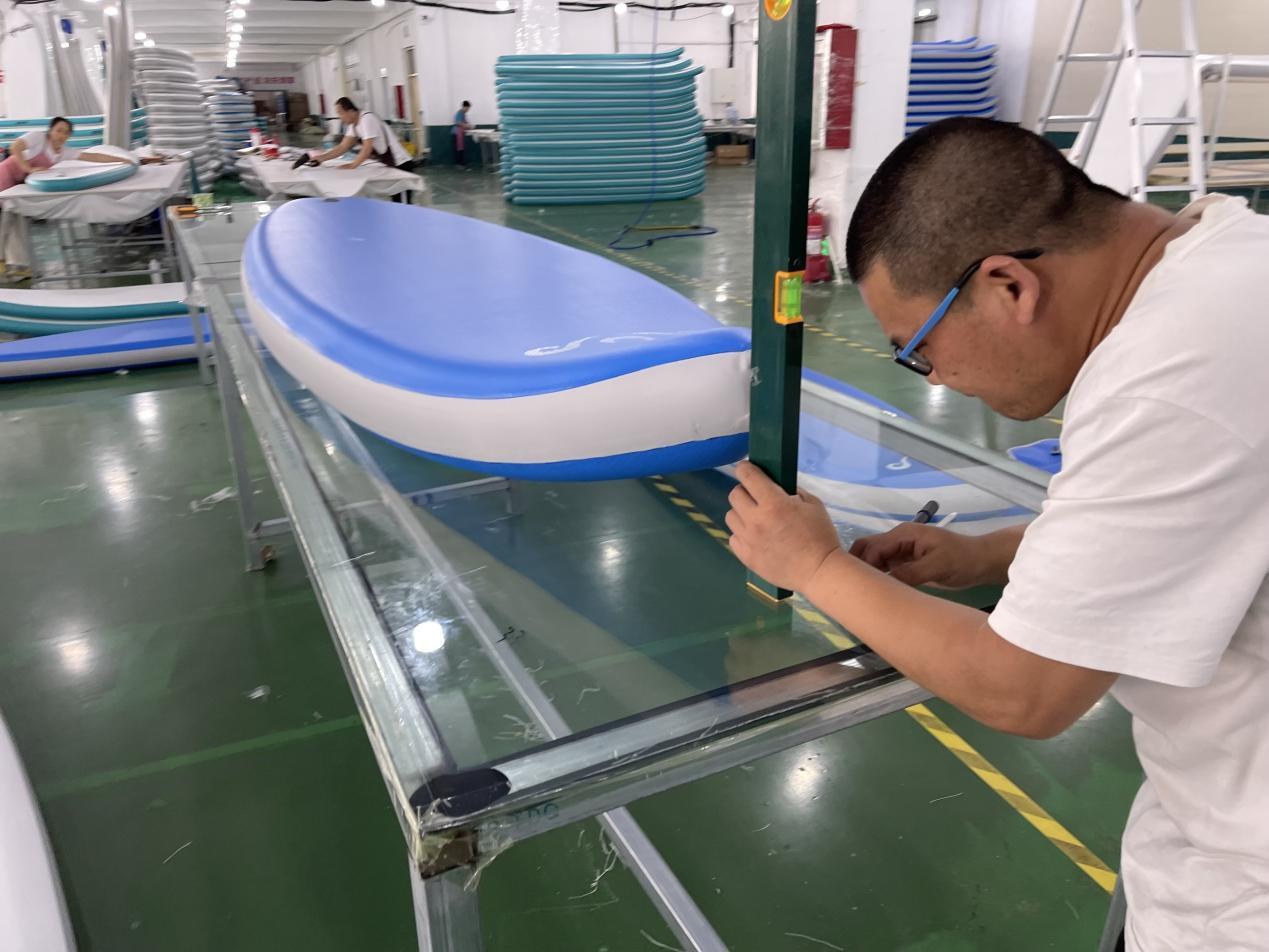 Technician checking alignment during inflatable board production